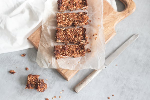 Delicious homemade granola bars on a wooden board, perfect for healthy snacking and meal preparation.